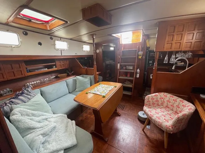 Interior of 1981 Endeavour 43 Center Cockpit Ketch with cozy seating and wooden finishes.