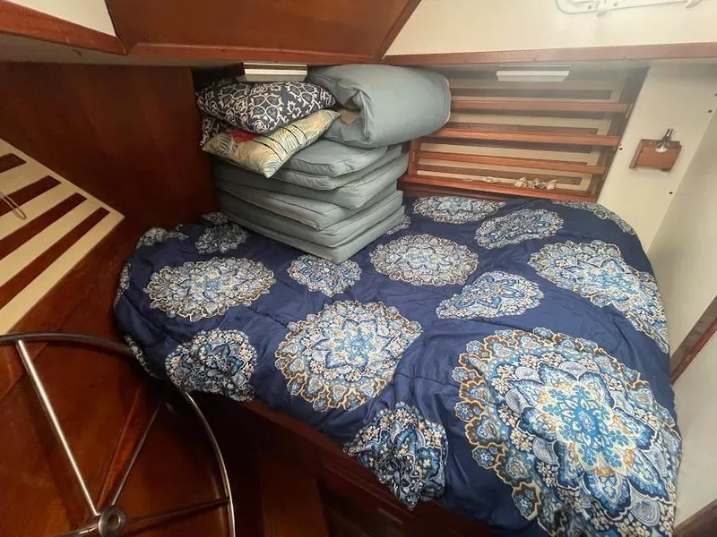 Cozy cabin interior of 1981 Endeavour 43 Center Cockpit Ketch with patterned bedding.