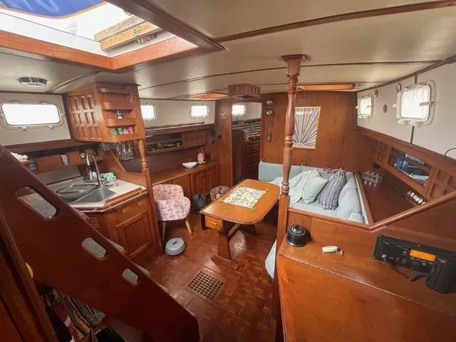 Interior of 1981 Endeavour 43 Center Cockpit Ketch, featuring cozy seating and wooden cabinetry.