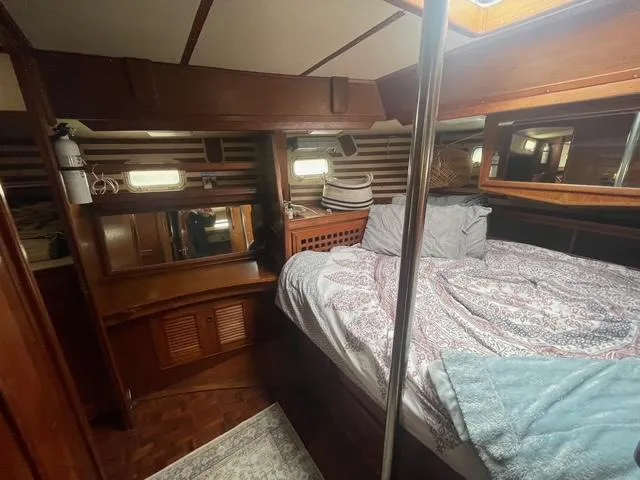 Cozy cabin interior of 1981 Endeavour 43 Center Cockpit Ketch with bed and wooden furnishings.
