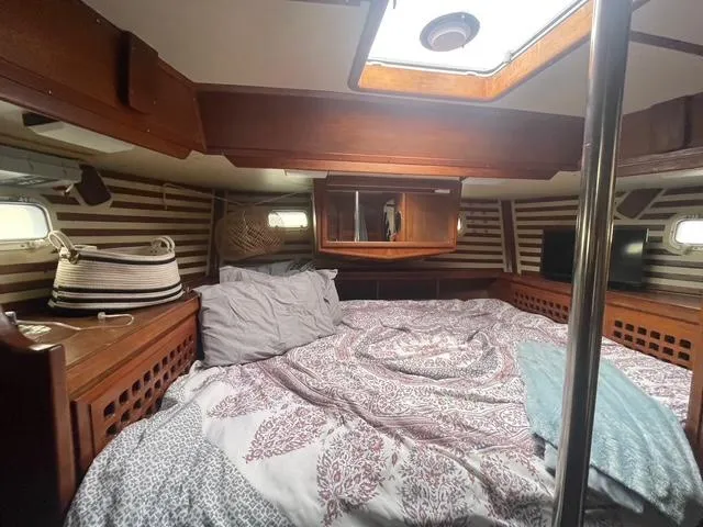 Cozy cabin interior of 1981 Endeavour 43 Center Cockpit Ketch with striped walls and bedding.