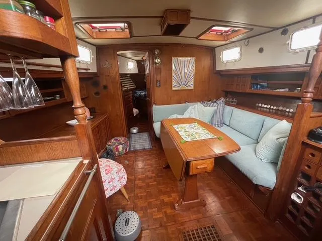 Cozy interior of 1981 Endeavour 43 Center Cockpit Ketch with wooden furnishings and seating area.