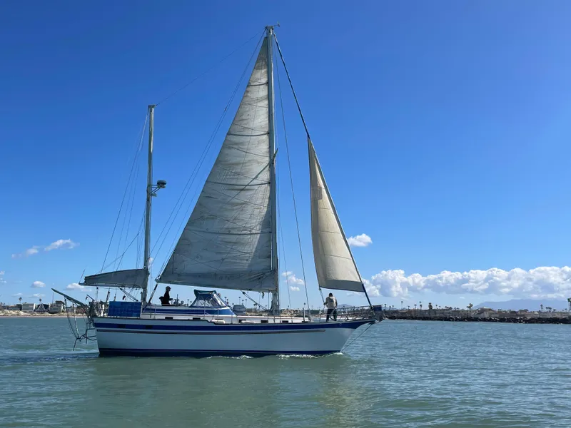 1981 Endeavour 43 Center Cockpit Ketch sailing on calm waters under a clear blue sky.