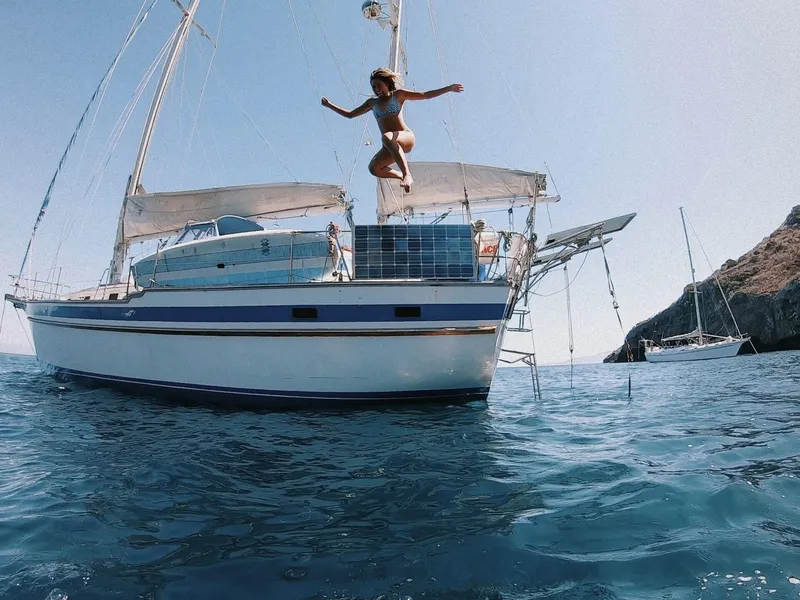 Woman jumping off 1981 Endeavour 43 Center Cockpit Ketch into the sea.