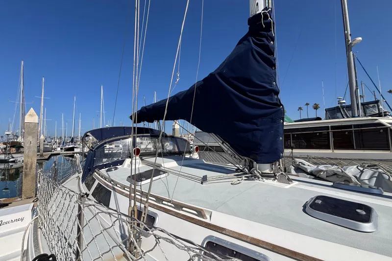 Sailboat Catalina 42, 1990 model, docked at marina under clear blue sky.