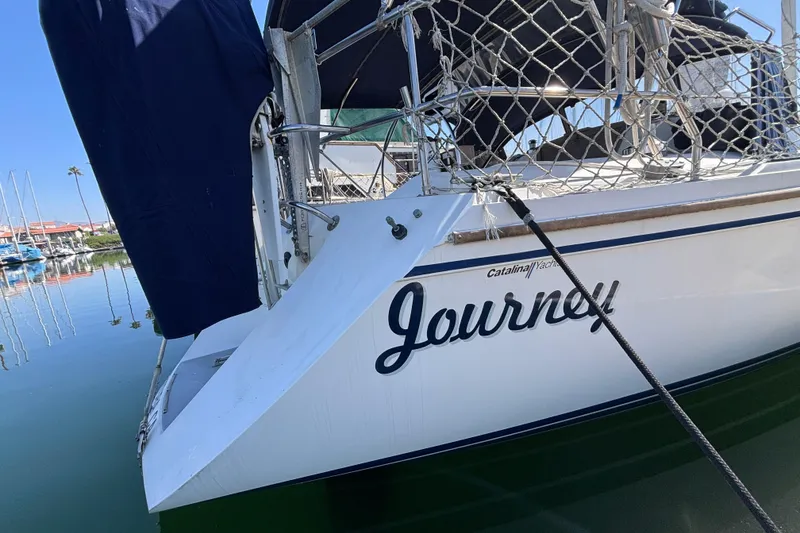 1990 Catalina 42 sailboat named "Journey" docked in a marina.