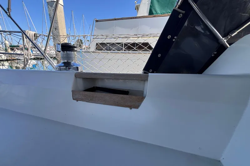 Sailboat deck detail of a 1990 Catalina 42, featuring winch and railing.