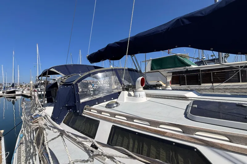 Sailboat Catalina 42, 1990 model, docked at marina under clear blue sky.