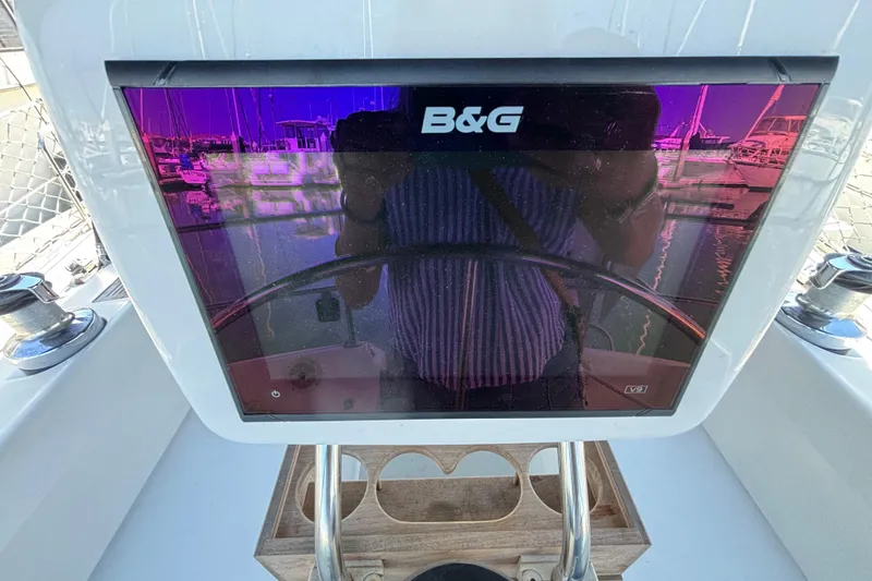 B&G navigation display on a 1990 Catalina 42 sailboat, reflecting marina scenery.