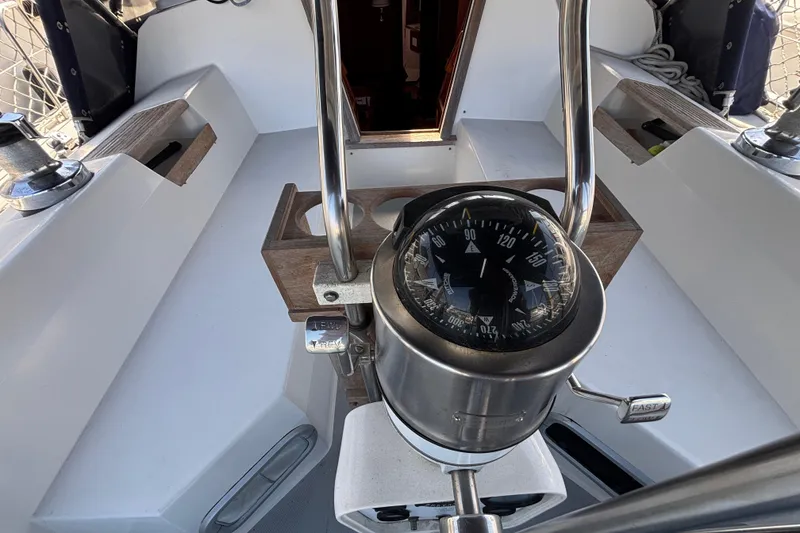 Cockpit of a 1990 Catalina 42 sailboat featuring a compass and steering wheel.