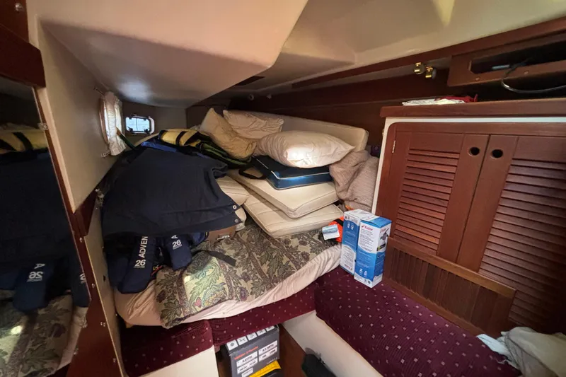 Cozy cabin interior of a 1990 Catalina 42 sailboat with cushions and storage.