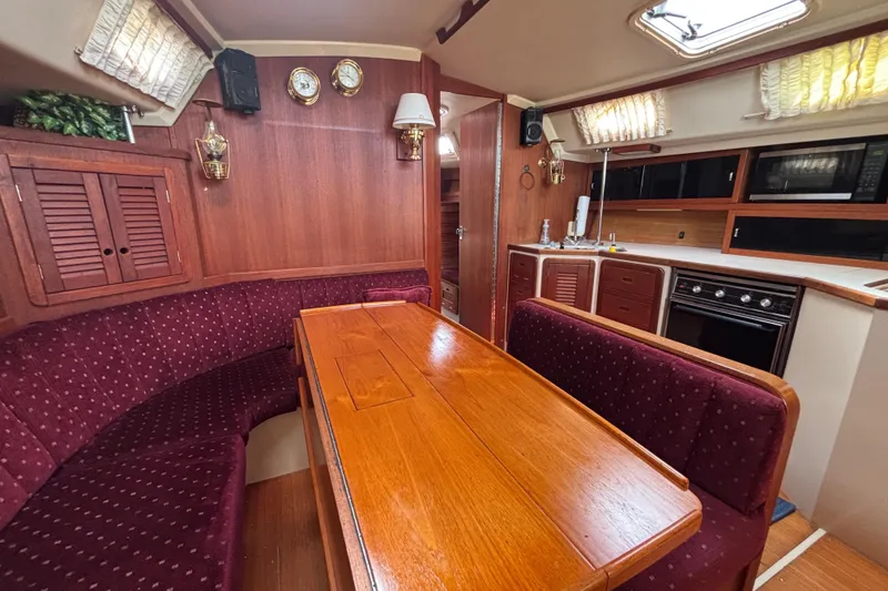 Interior of a 1990 Catalina 42 yacht with wood finishes and cozy seating area.