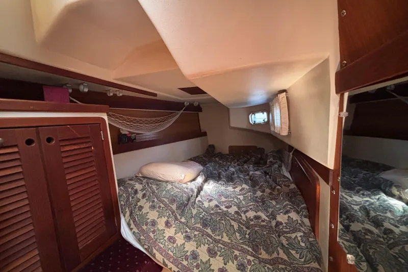 Cozy cabin interior of a 1990 Catalina 42 sailboat with a floral bedspread.