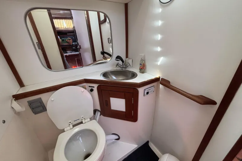 Bathroom interior of a 1990 Catalina 42 sailboat with sink and toilet.