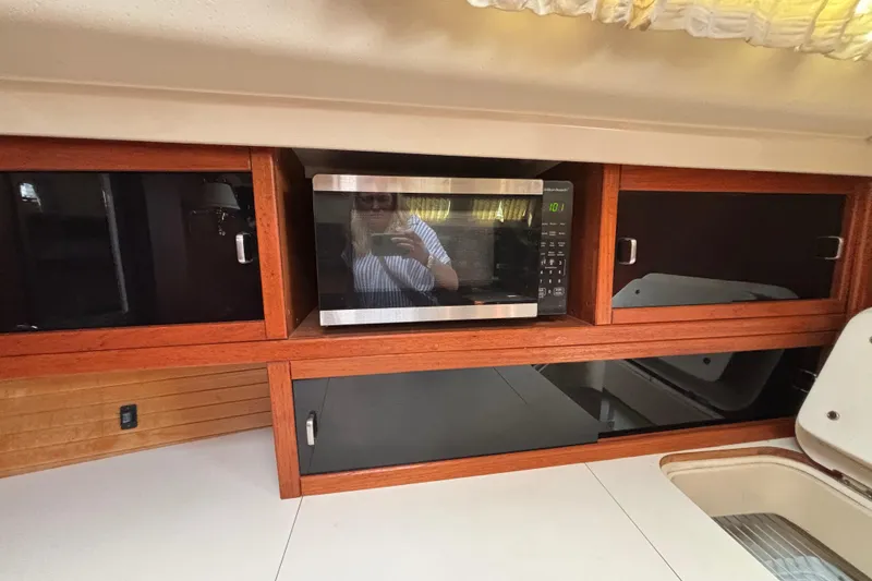 Interior of 1990 Catalina 42 yacht with microwave and wooden cabinetry.