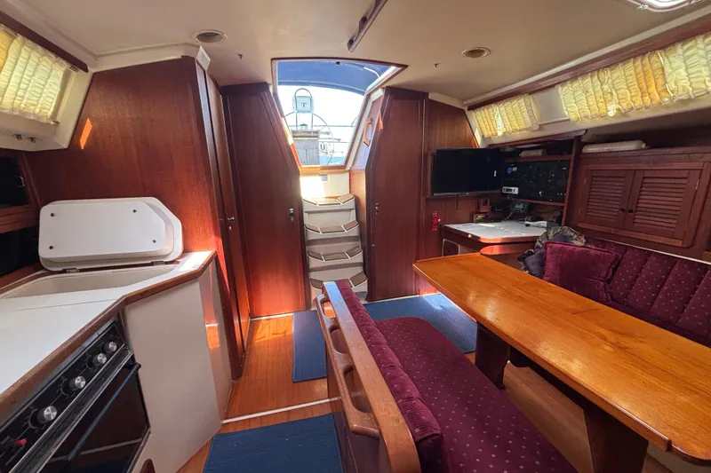 Interior of a 1990 Catalina 42 sailboat with wood finish and cozy seating area.