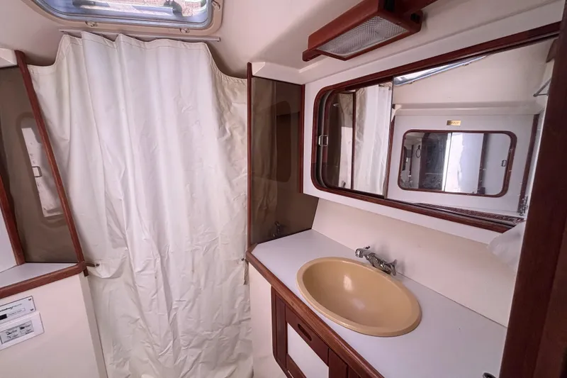 Bathroom interior of a 1990 Catalina 42 sailboat with sink and mirror.