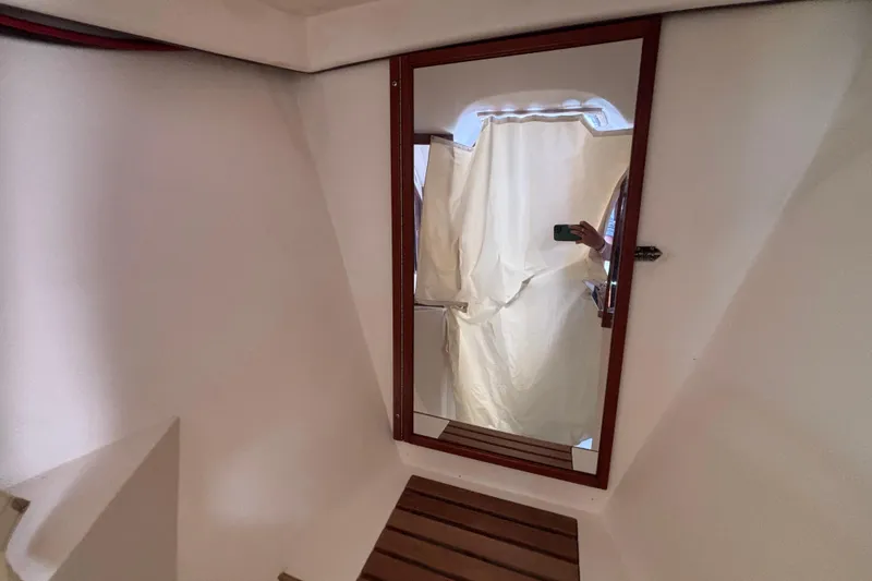 Mirror reflection inside 1990 Catalina 42 yacht cabin with wooden accents.