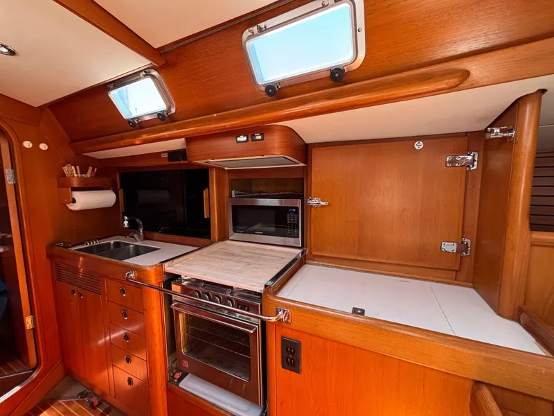 Interior of 1994 Nautor Swan 46 MK II yacht kitchen with wood cabinetry and appliances.