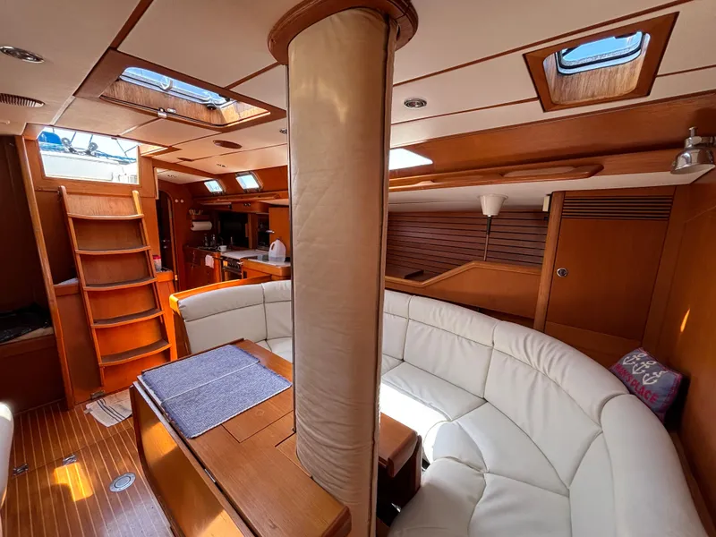 Luxurious interior of 1994 Nautor Swan 46 MK II yacht with elegant wood and white seating.