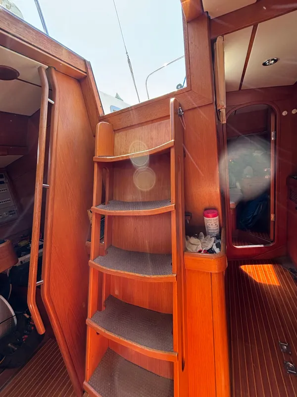 Interior of 1994 Nautor Swan 46 MK II sailboat with wooden steps and cozy cabin.