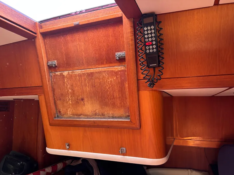 Interior of 1994 Nautor Swan 46 MK II yacht with wooden cabinetry and mounted radio.