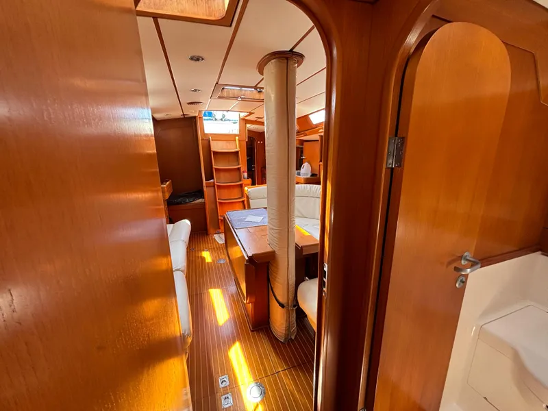 Interior of 1994 Nautor Swan 46 MK II yacht, featuring wooden finishes and cozy seating.