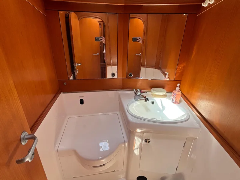 Elegant bathroom in 1994 Nautor Swan 46 MK II yacht with wooden cabinetry and modern fixtures.