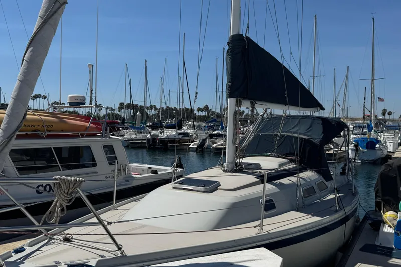 1989 Ericson Sloop sailboat docked in a marina under clear blue skies.
