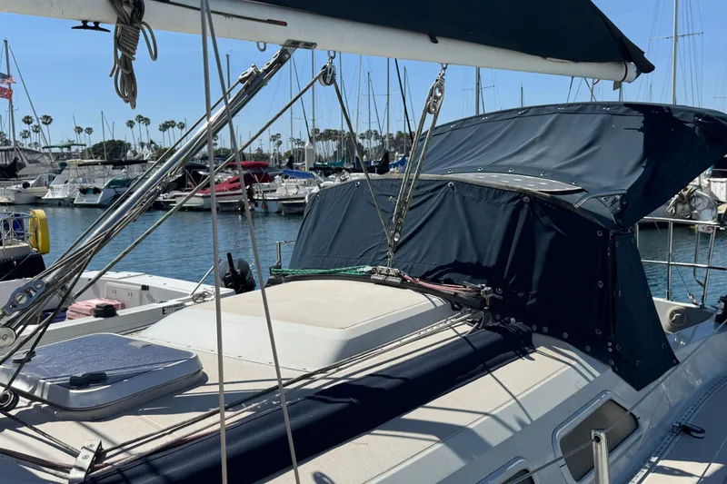 1989 Ericson Sloop sailboat docked in marina, surrounded by other boats and clear blue sky.