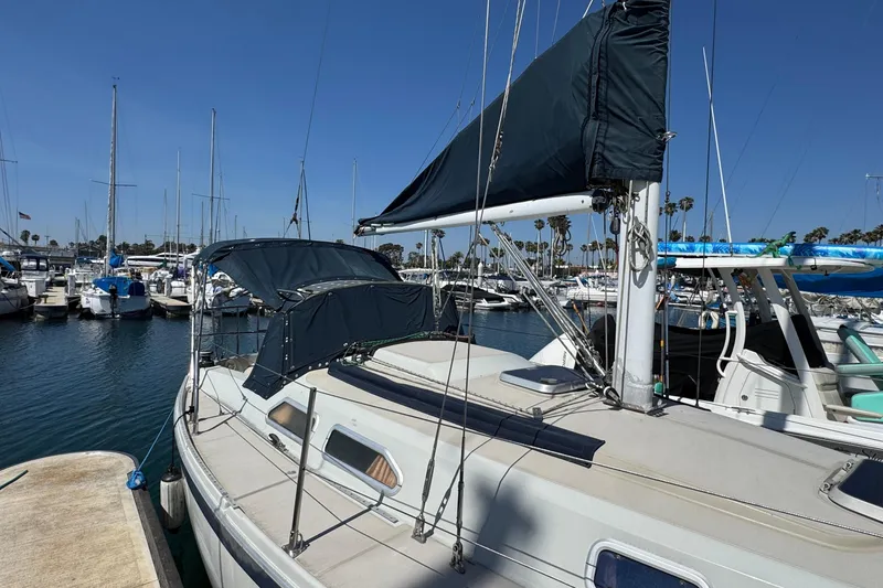 1989 Ericson Sloop sailboat docked in a marina under clear blue skies.