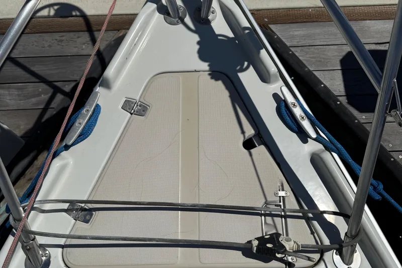 Bow of 1989 Ericson Sloop with ropes and deck fittings in sunlight.