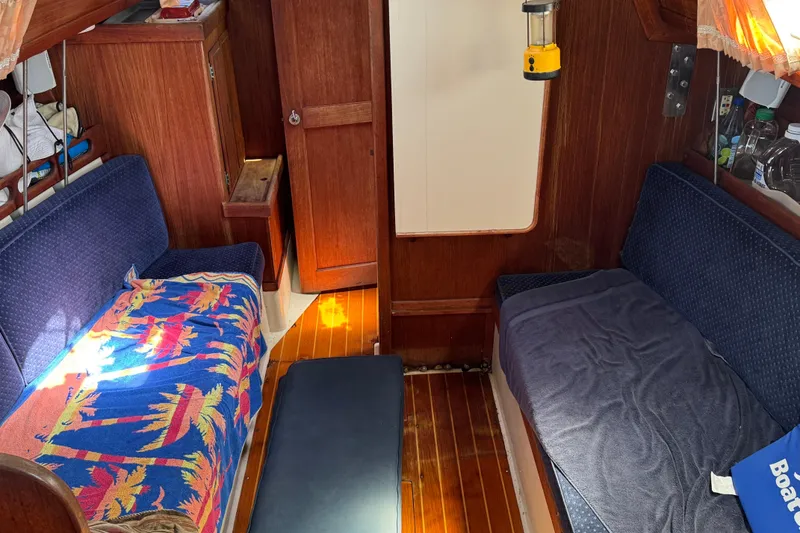 Interior of a 1989 Ericson Sloop sailboat with cozy seating and wooden finishes.