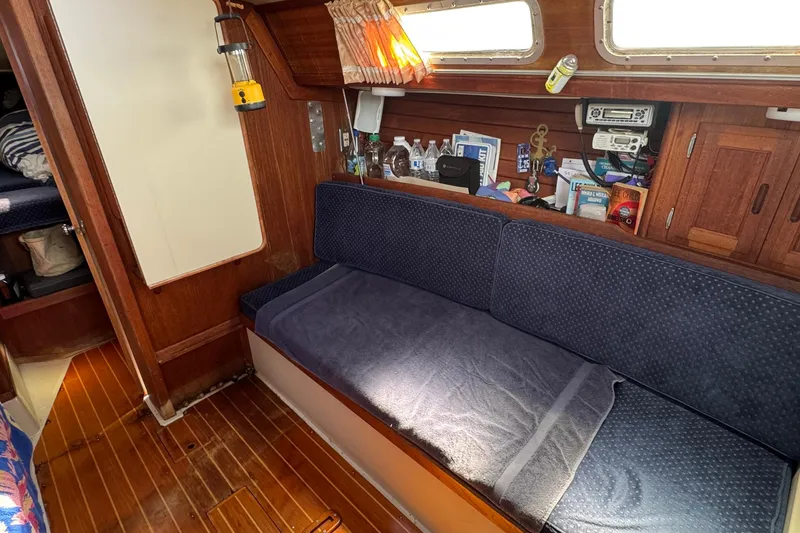 Interior of a 1989 Ericson Sloop sailboat with cozy seating and wooden accents.
