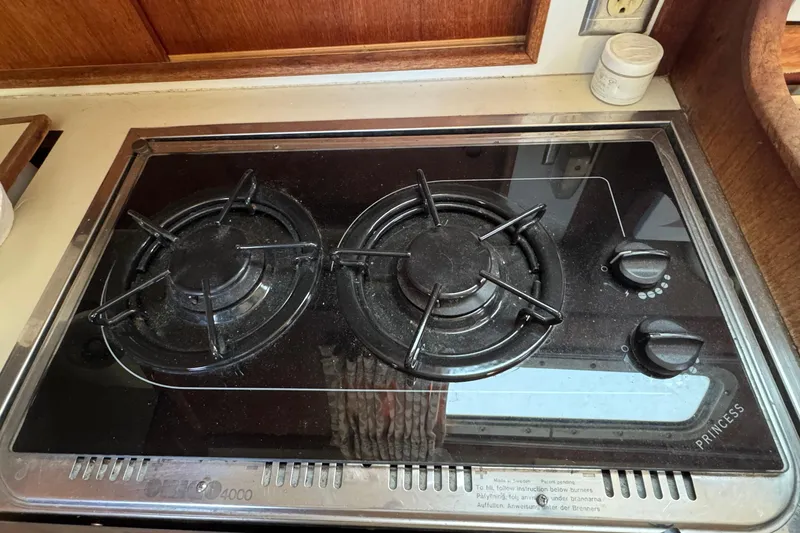 Gas stove on 1989 Ericson Sloop yacht, featuring dual burners and control knobs.