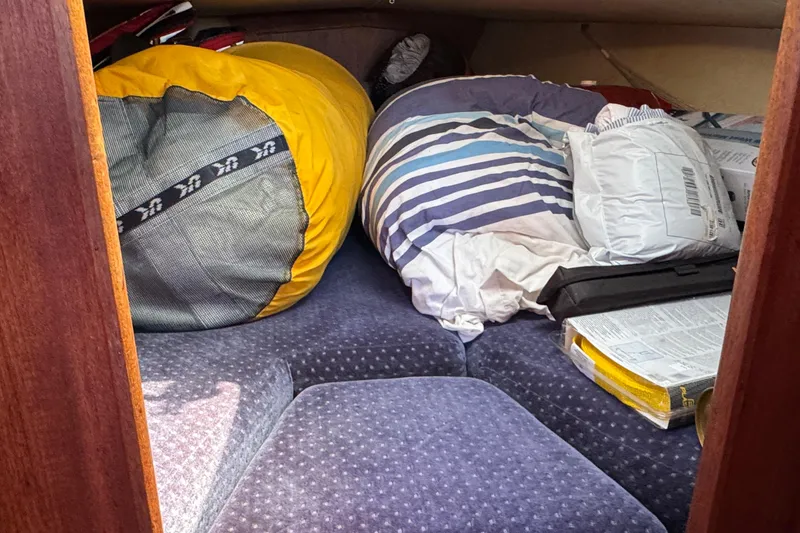 Cozy cabin interior of 1989 Ericson Sloop with cushions and storage items.