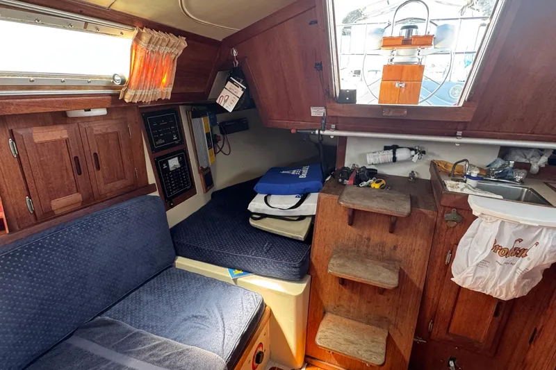 Interior of a 1989 Ericson Sloop sailboat with wooden cabinetry and seating.
