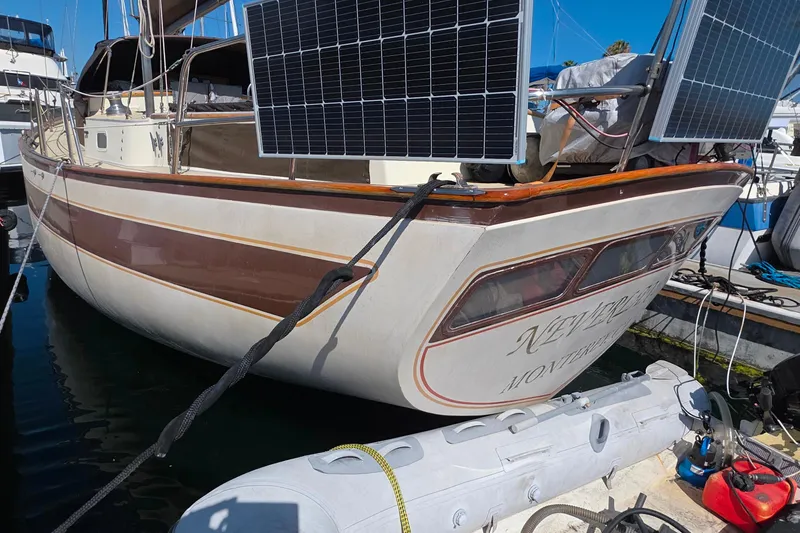 1978 Islander Freeport 41 sailboat with solar panels docked at marina.