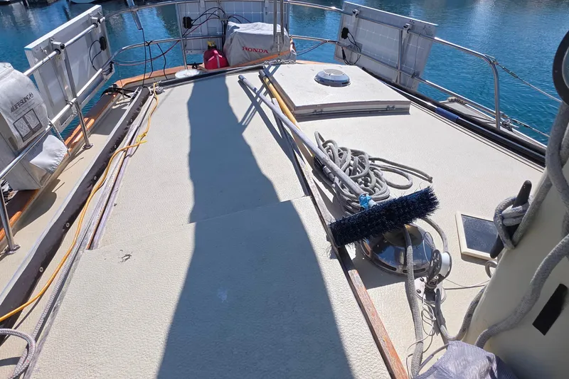 Deck of 1978 Islander Freeport 41 sailboat with ropes and cleaning brush.