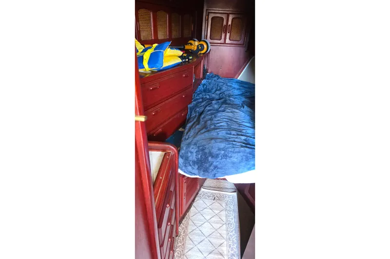 Interior cabin of 1978 Islander Freeport 41 sailboat with wooden furnishings and bedding.