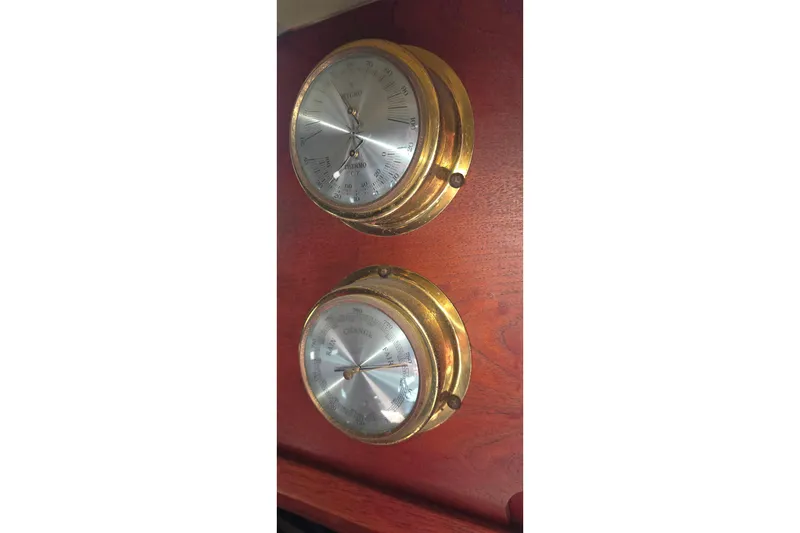 Brass nautical instruments on 1978 Islander Freeport 41 yacht, mounted on wooden panel.
