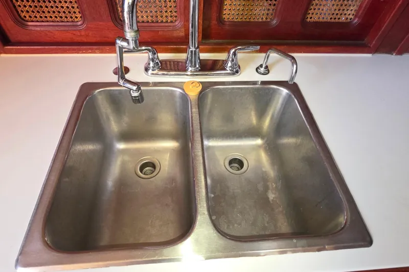 Double stainless steel sink with faucet on Islander Freeport 41, 1978 model yacht.