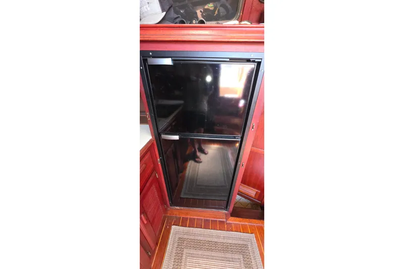 Refrigerator in 1978 Islander Freeport 41 yacht interior with wooden cabinetry.