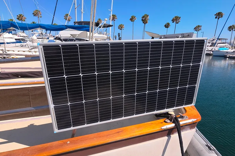 Solar panel on 1978 Islander Freeport 41 sailboat in marina with palm trees.