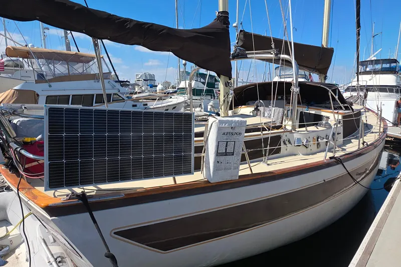 1978 Islander Freeport 41 sailboat with solar panel docked at marina.