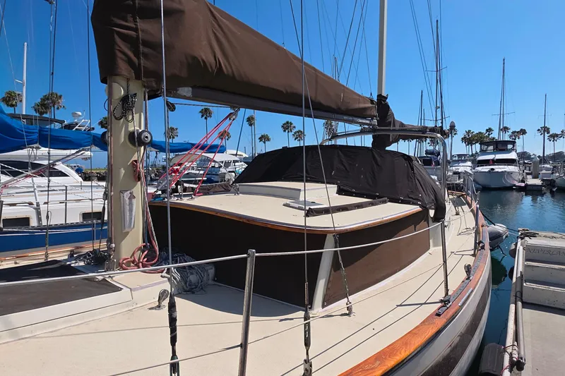 1978 Islander Freeport 41 sailboat docked in marina, featuring brown sail cover.