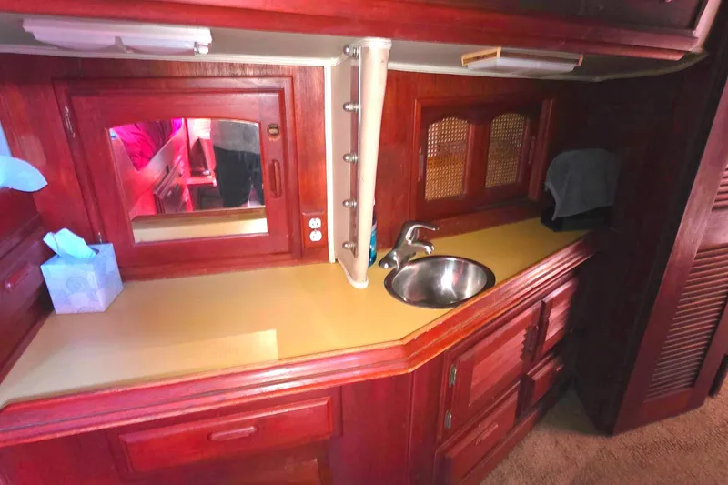 Interior of 1978 Islander Freeport 41 yacht with wooden cabinetry and compact sink area.