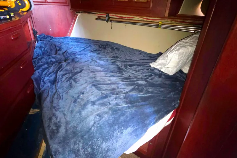 Cozy cabin bed with blue blanket in 1978 Islander Freeport 41 sailboat.