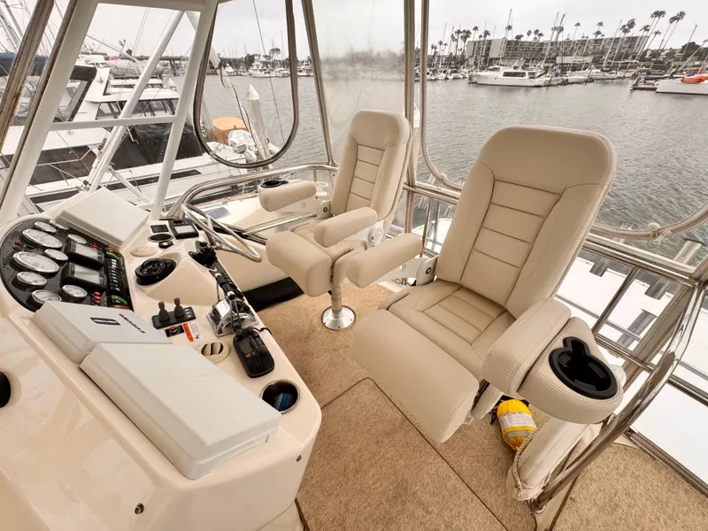 2004 Riviera 47 Flybridge helm with beige seats and marina view.