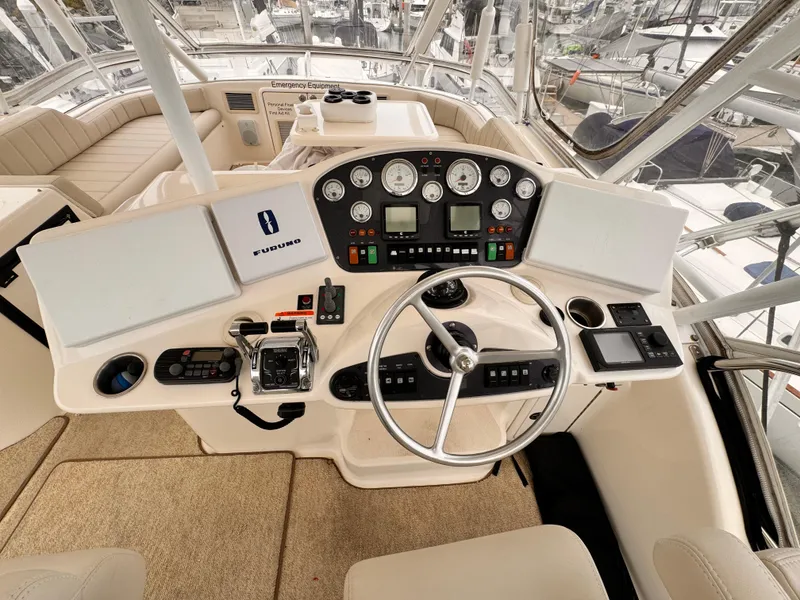 2004 Riviera 47 Flybridge helm with steering wheel, gauges, and navigation controls.